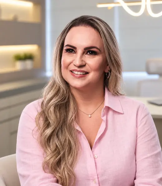 Dra. Luana Arivabeni sorrindo, no consultório em Colatina